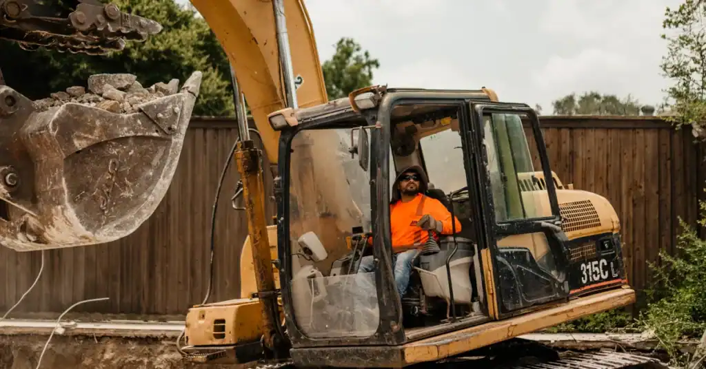 JRP Demolition excavator loading broken concrete during a house demolition in Houston